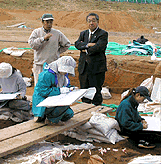 発掘調査を視察する田岡市長（右）の写真