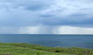 写真：沖を雲が覆い雨が降る様子